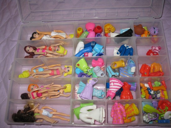 Caixa com divisórias para bonecas pequenas e seus acessórios.