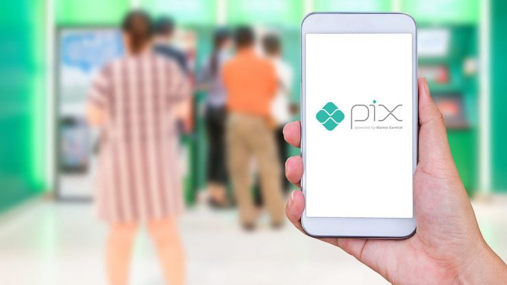 Pessoas em uma fila e uma mão segurando app com Pix aberto