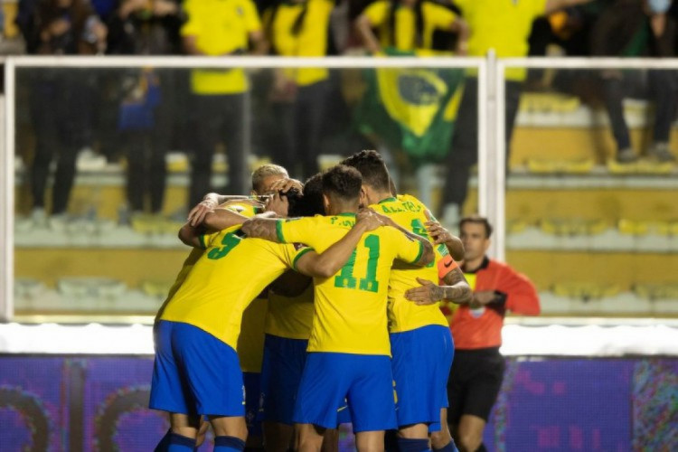 Foto de jogadores da Seleção Brasileira se abraçando em campo