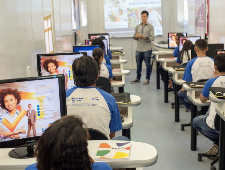 Imagem mostra estudantes do Senac em um curso. A sala de aula está lotada e ao centro há a presença de um professor