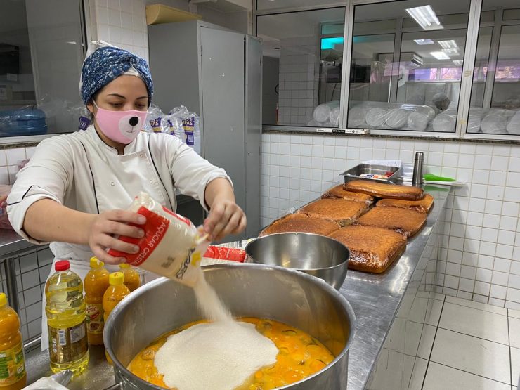 Mulher preparando comida na cozinha do Senac para ação solidária