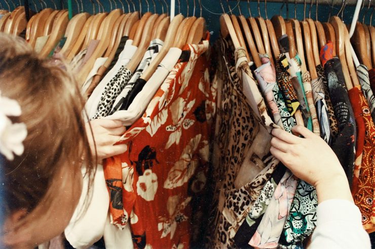 Mulher abrindo arara de roupas; autoconhecimento pode ser expressado através da moda