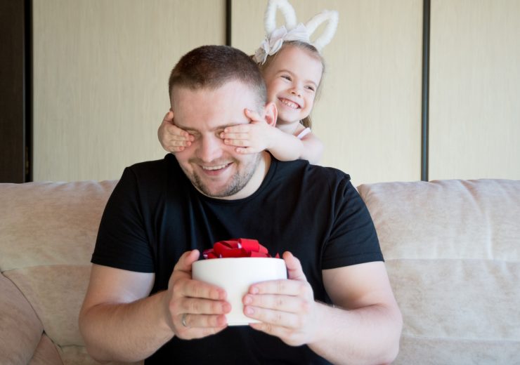 Menina com tiara de coelhinho, tapando os olhos de homem; confira sugestões para o Dia dos Pais