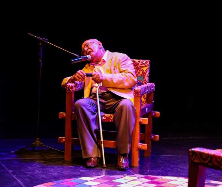 Pedro Bandeira sentado em uma cadeira, falando no microfone
