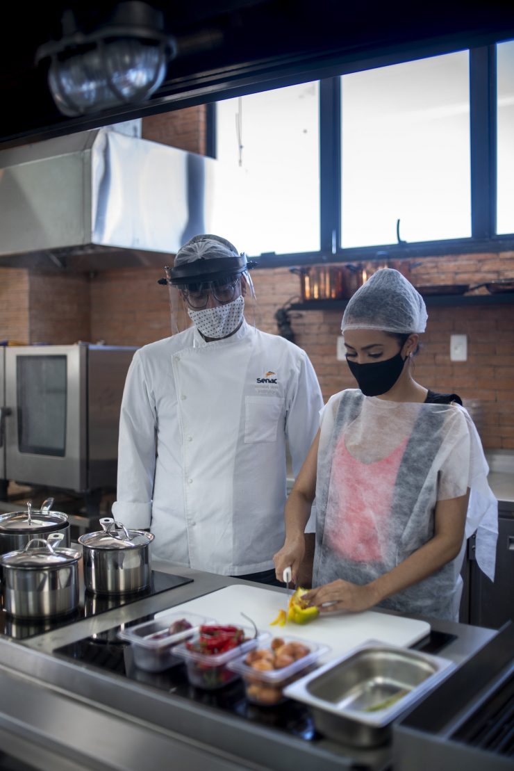Duas pessoas com equipamento, cortando frutas; cursos de gastronomia são parte da Semana Brasil