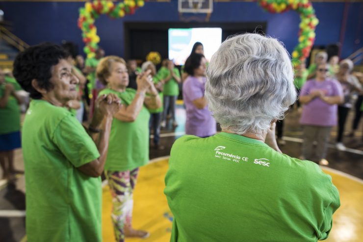 Senhoras idosas em roda, com blusas do Sesc; envelhecimento é tema de evento online