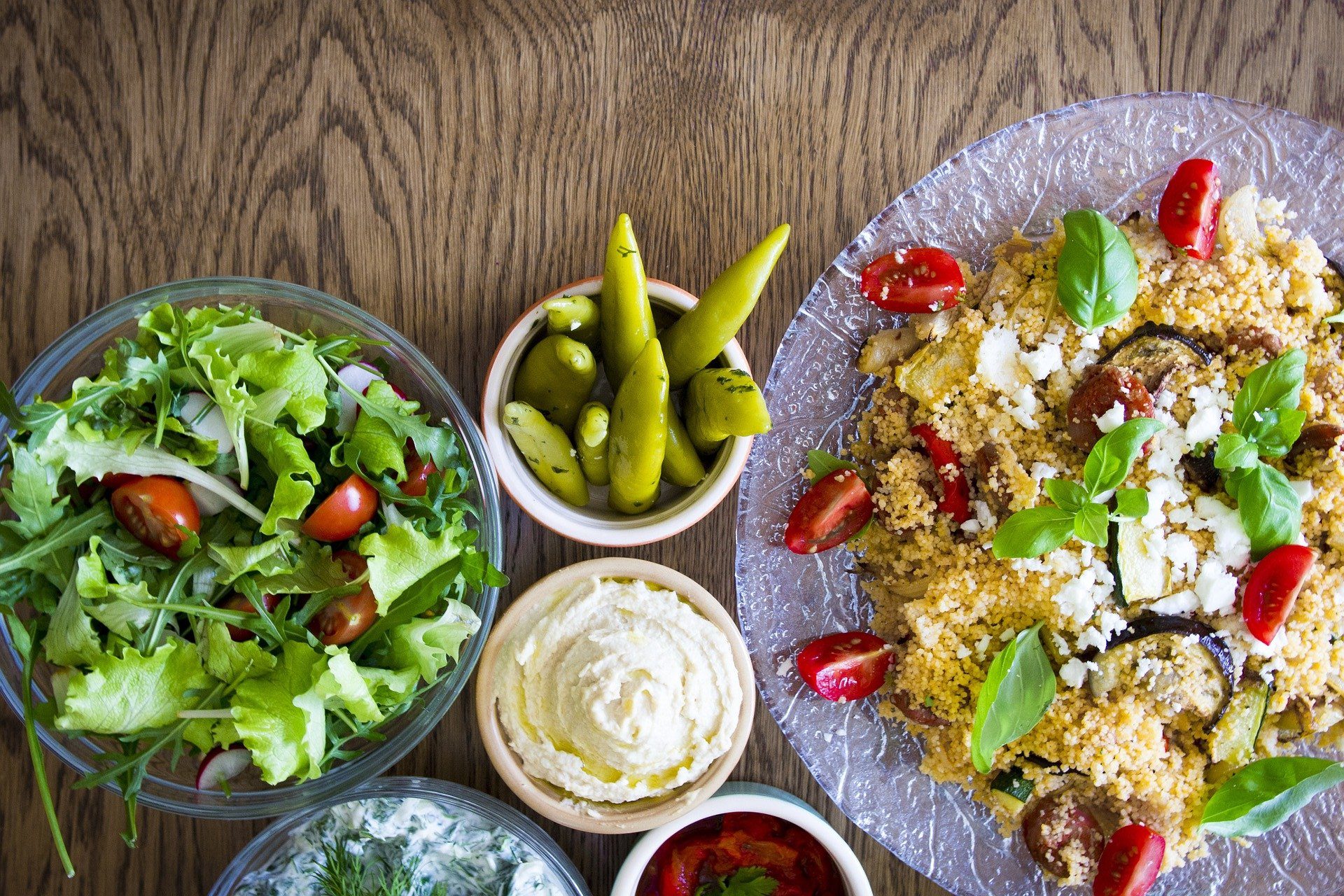Cuscuz: na imagem, à direita, um prato de cuscuz marroquino. À esquerda, há vários potinhos com saladas e molhos.