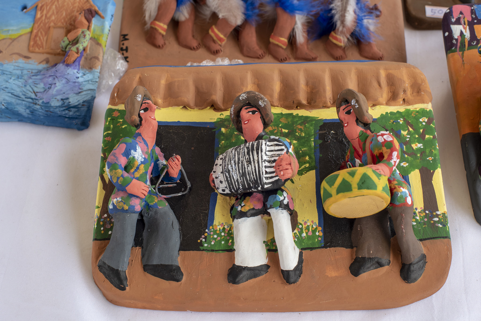 Herança Nativa: na foto, três bonecos de barro tocam instrumentos, caracterizados como sertanejos.
