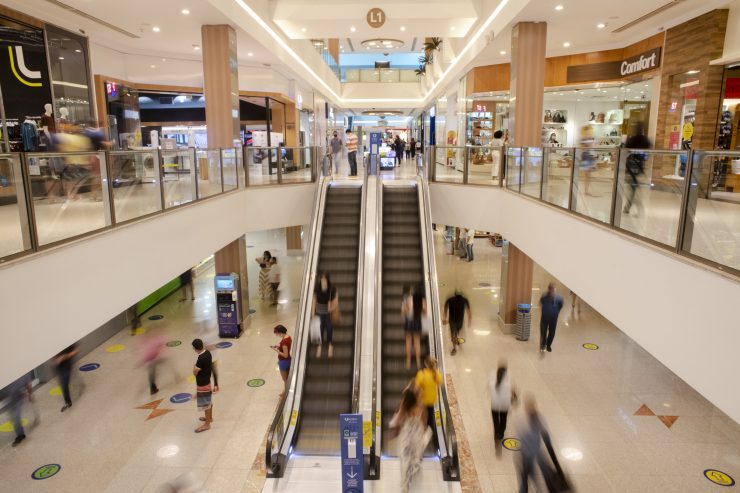 inovação: na imagem, vista de shopping com escadas rolantes, lojas e pessoas passando