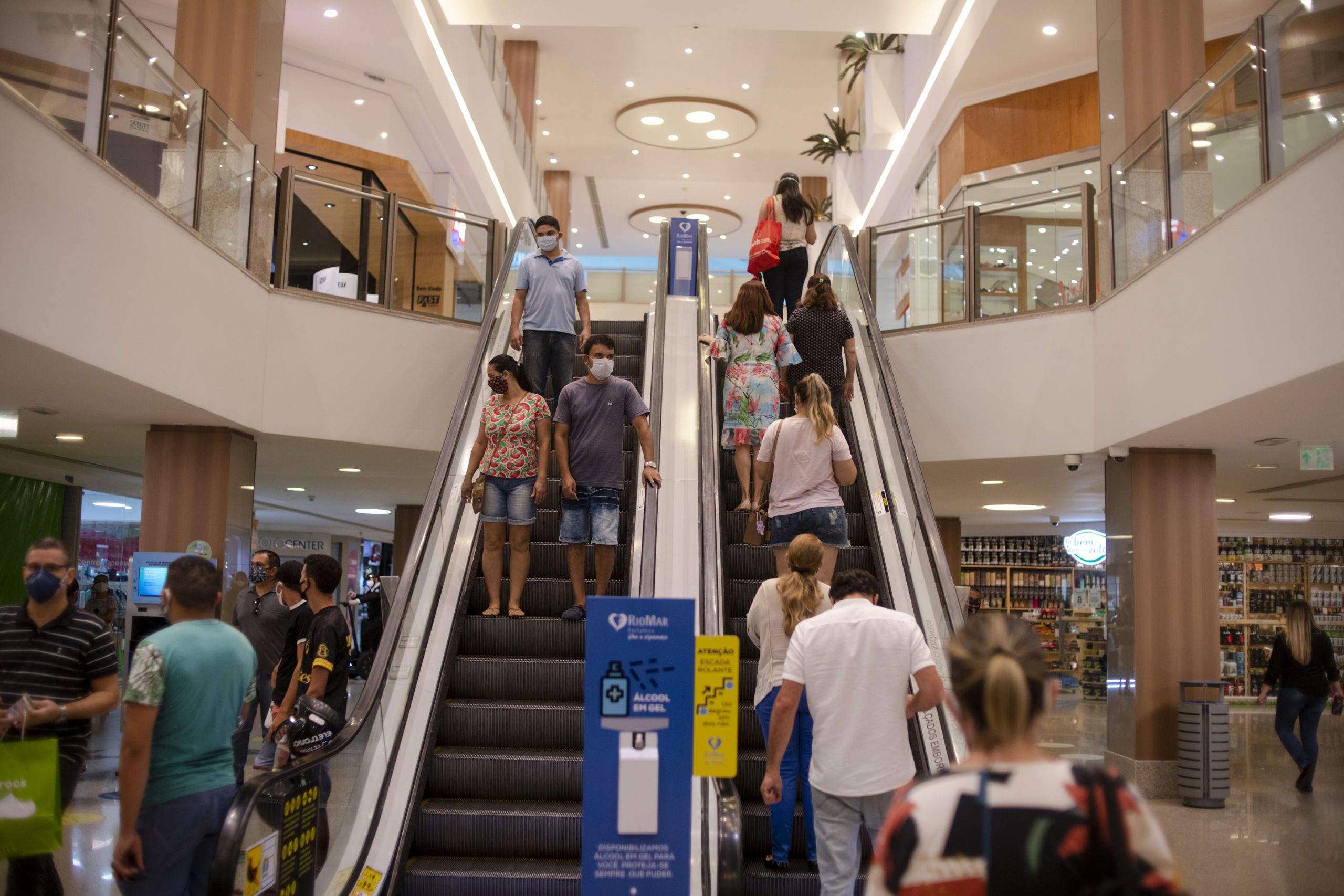 Carnaval: foto mostra duas escadas rolantes de um shopping, com várias pessoas subindo e descendo.