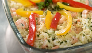 Arroz de camarão: foto mostra close no prato, em que aparecem pimentões coloridos, camarões e arroz.