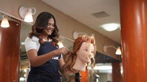 mercado de trabalho: na imagem, mulher treinando corte de cabelo