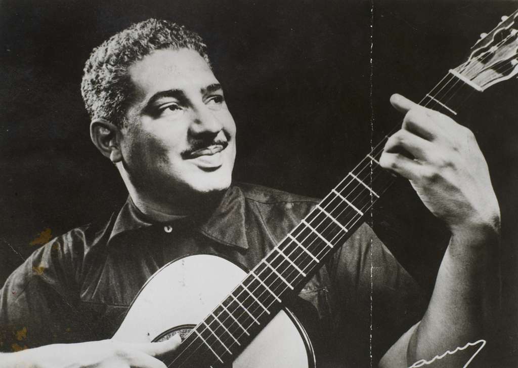Viva Caymmi: foto preto e branco do cantor Dorival Caymmi tocando violão