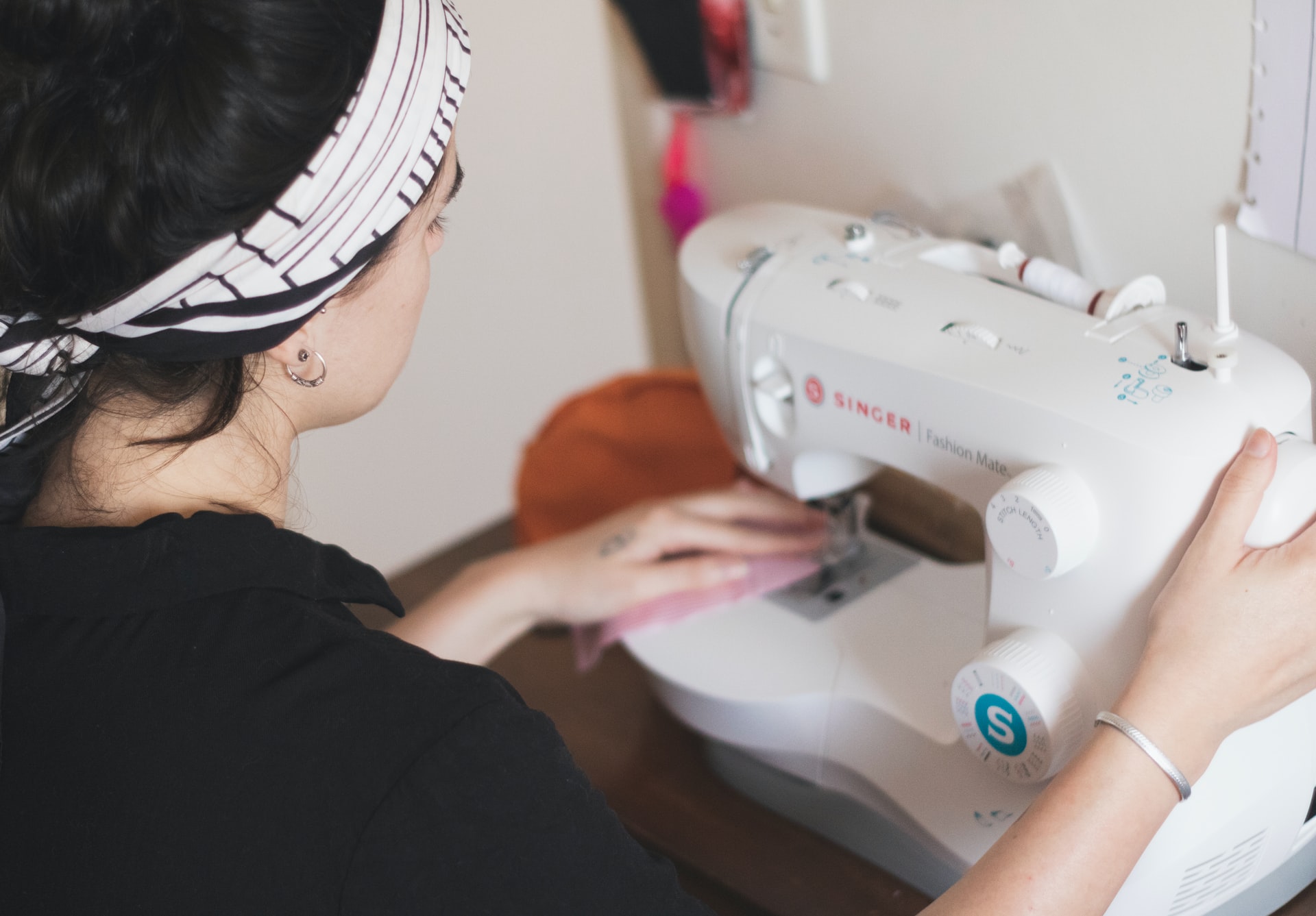Trabalhar com moda: a imagem mostra uma mulher trabalhando em uma máquina de costura